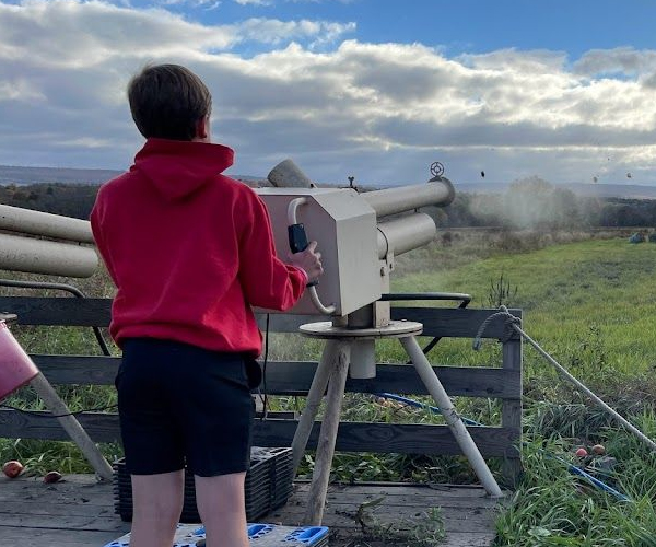 child firing apple cannon