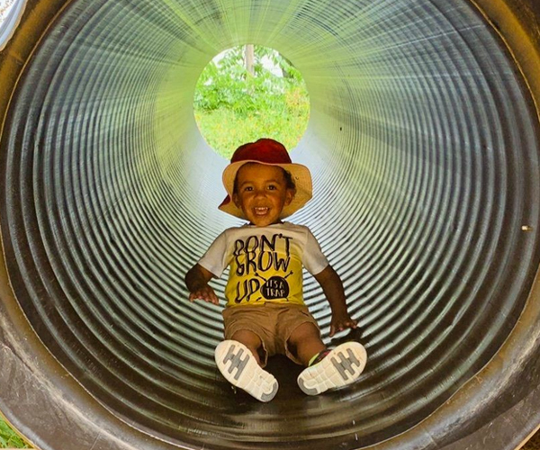 young child in tube slide